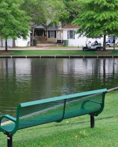 Boy fishing at one of the freshwater lakes inside Ocean Lakes campground with a golf cart visible in the background